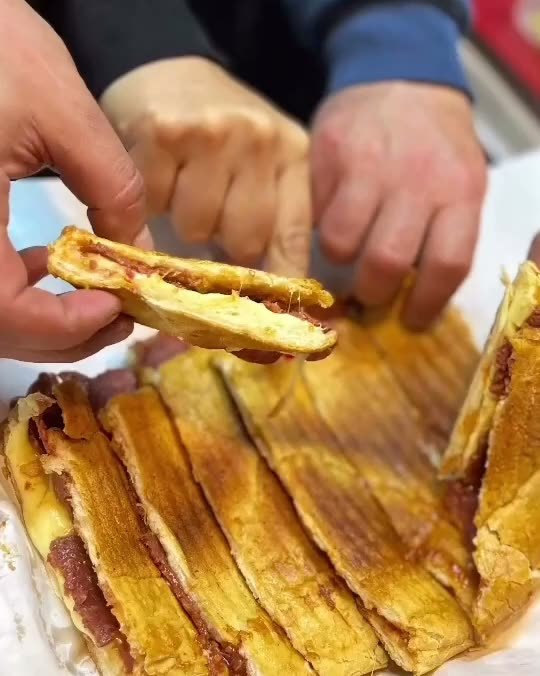 Izgara izli karışık tost dilimleri, bir dilim elle kaldırılmış.