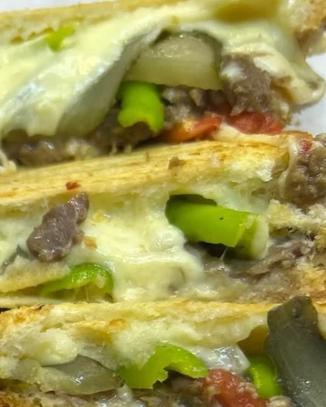 Kesilmiş kavurmalı tost dilimleri, arasında erimiş kaşar ve yeşil biber.